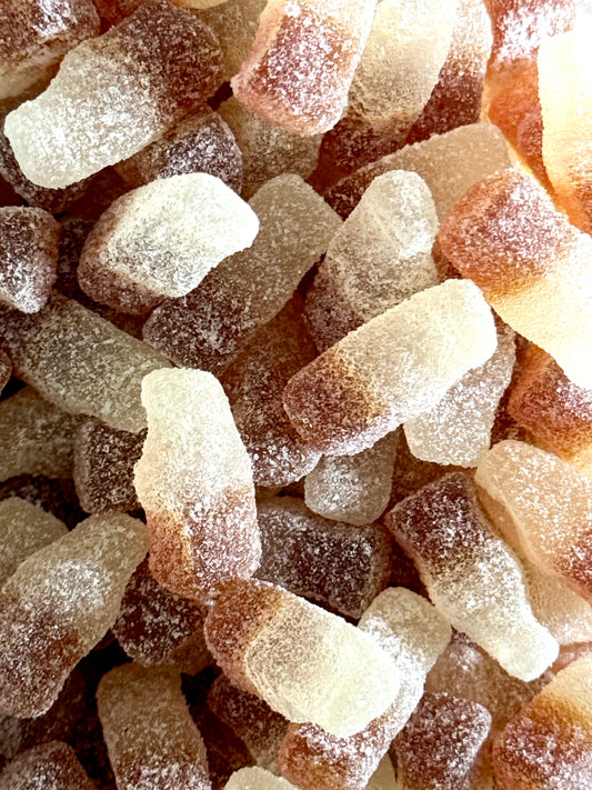 Mouth watering fizzy cola bottles in a sweet jar 